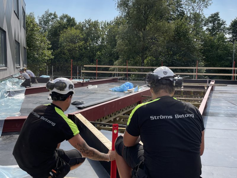 Två medarbetare från Ströms Betong mäter in vid kantformen på ett bjälklag