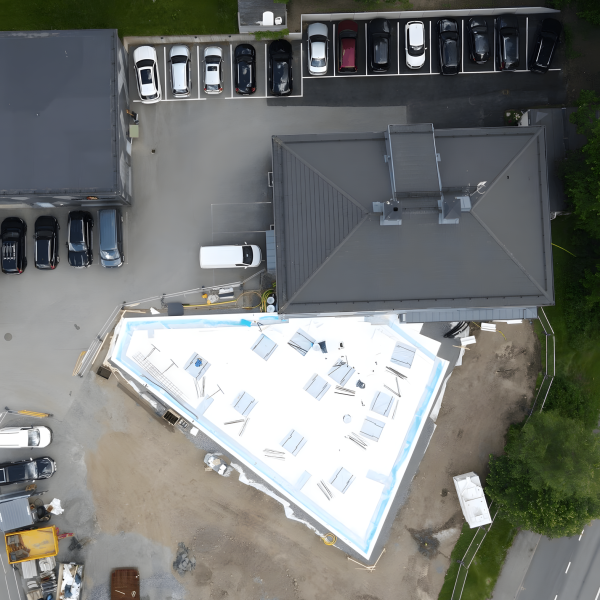 Flygbild över en tillbyggnad under uppförande intill en befintlig byggnad