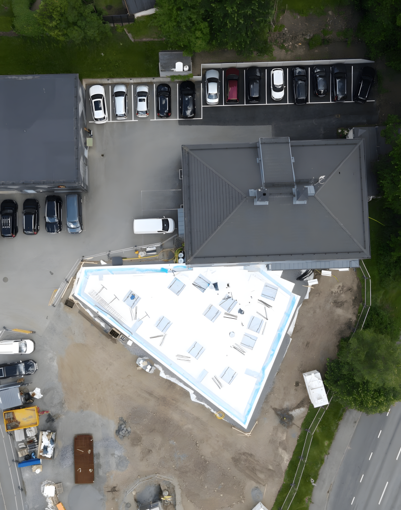 Flygbild över en tillbyggnad under uppförande intill en befintlig byggnad