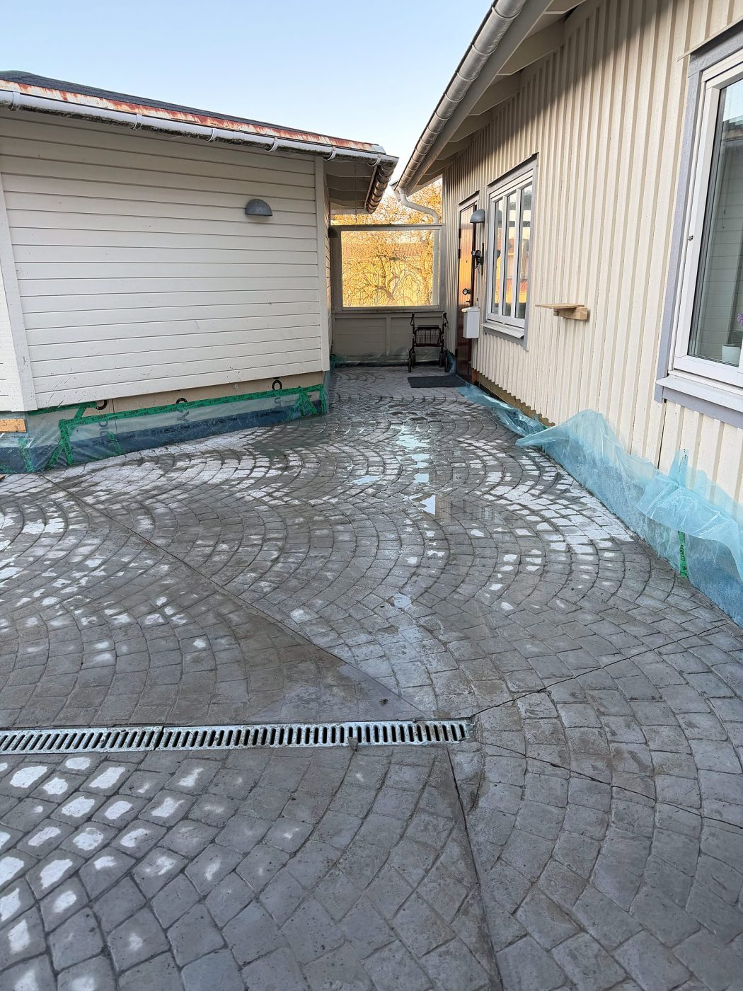 Gårdsplan i mönsterbetong med smågatsten i solfjädersmönster