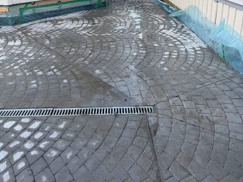 Gårdsplan i mönsterbetong med smågatsten i solfjädersmönster